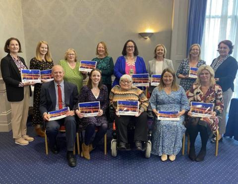 DISC members posing holding copies of the strategy.